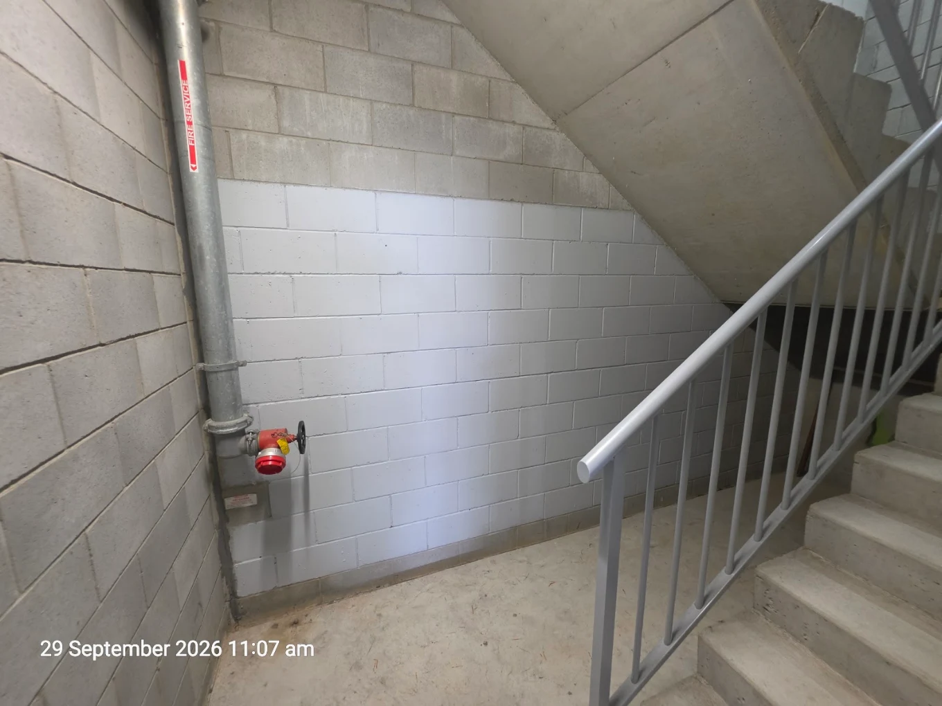 After graffiti removal at the same Tweed Heads strata property: cleaned stairwell wall beside the handrail